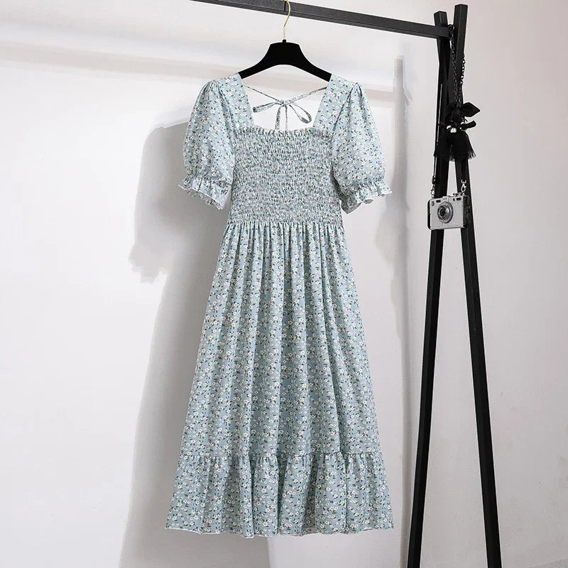 Women's blue floral chiffon dress with smocked bodice, short puff sleeves and a tiered maxi skirt.