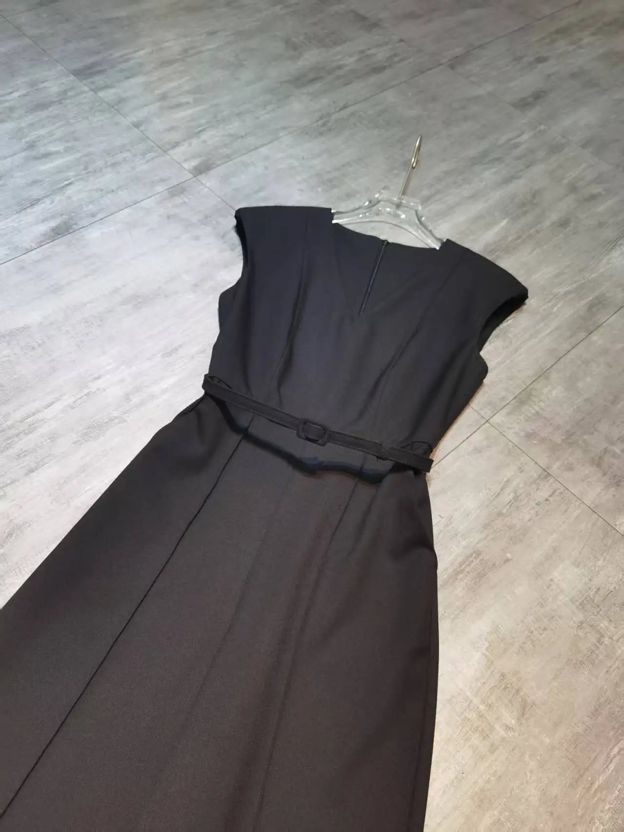 Elegant sleeveless trouser jumpsuit in a minimalist business style with belt