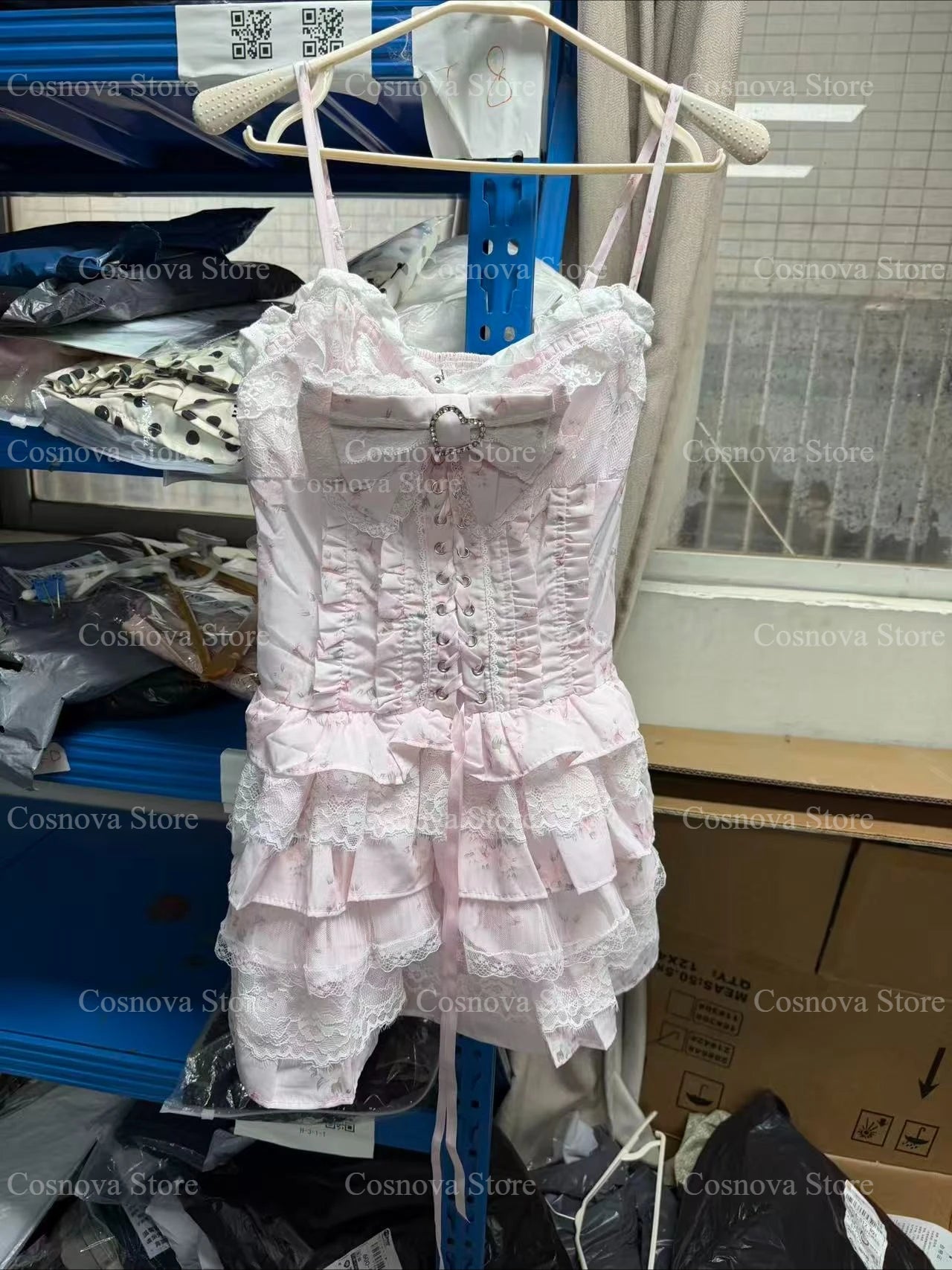 Pink lace two-piece Lolita set featuring a corset-style top with bow and a tiered ruffle mini skirt