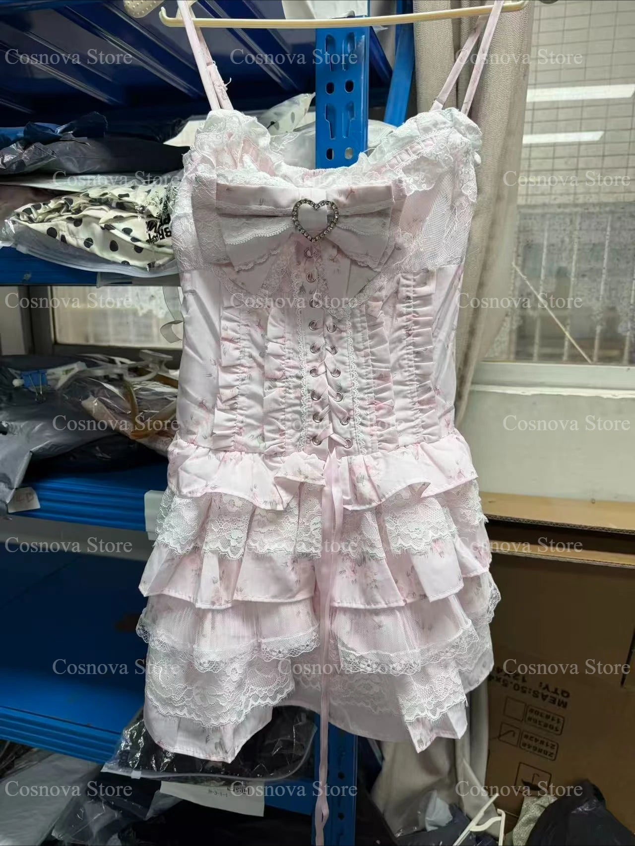Pink lace Japanese Sweet Lolita two-piece set with corset-style bodice, heart bow, and tiered ruffle skirt