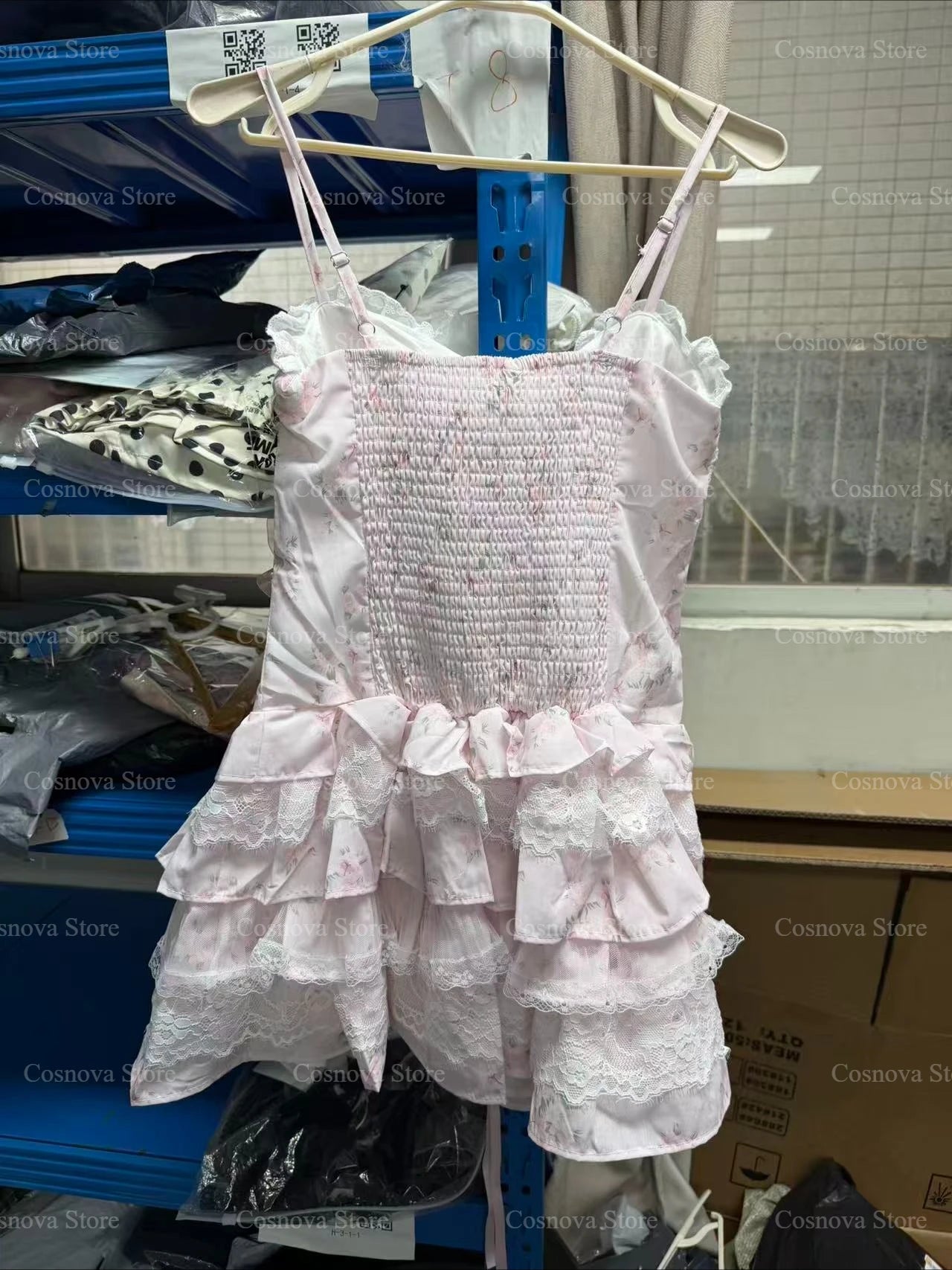 Pink Japanese Sweet Lolita lace two-piece set with smocked bodice and tiered ruffle skirt on hanger