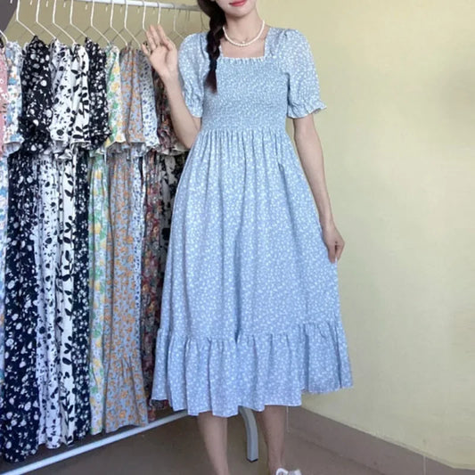 Dress in blue floral chiffon with short puff sleeves, smocked bodice, and tiered A-line midi.