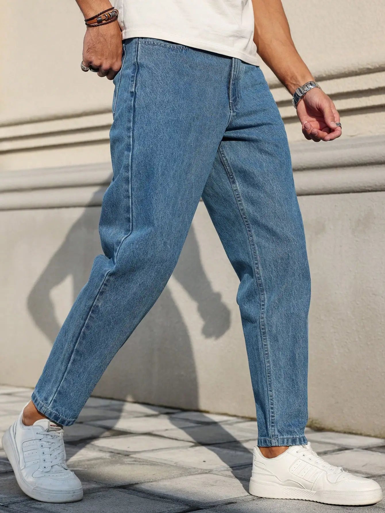 Men's jeans are made of classic blue denim fabric with a loose fit, making them an indispensable versatile item in the wardrobe.